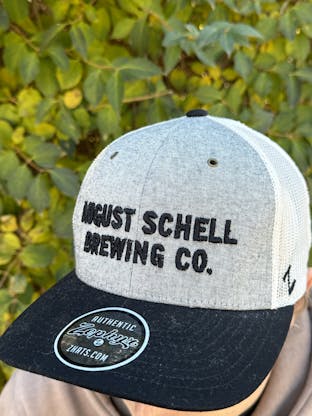 Black, grey and white baseball hat with Schell embroidered on front in black.