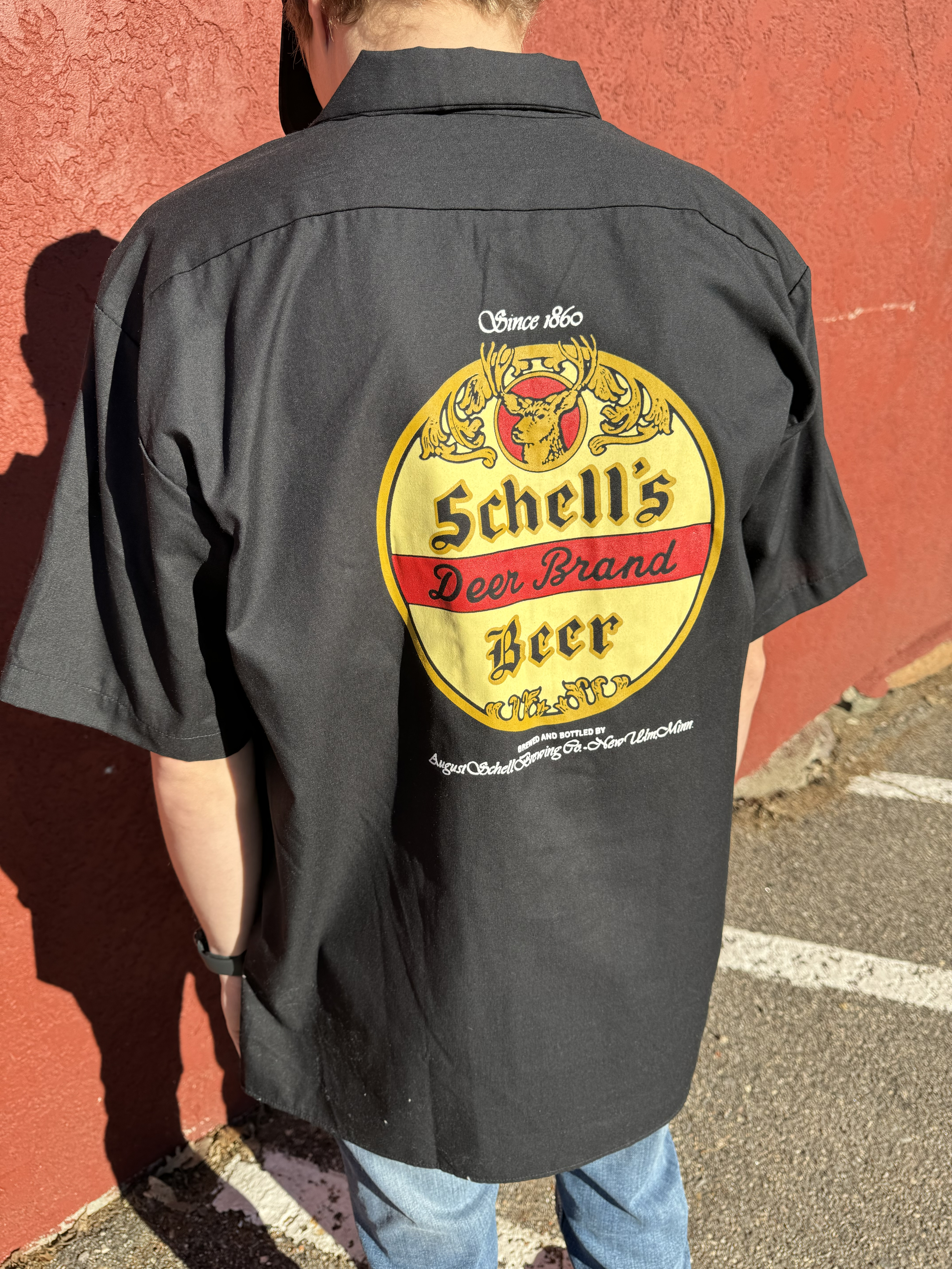 Black button up shirt with Schell logo on front and back.