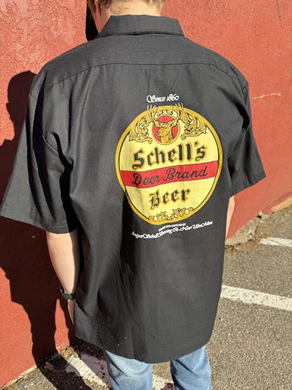 Black button up shirt with Schell logo on front and back.