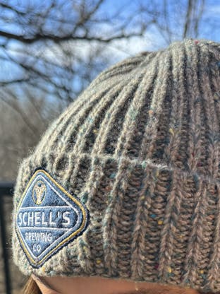 Blue and grey fleck stocking cap with Schell patch on front.