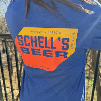 Blue long sleeve with orange and yellow Schell logo on front and back.