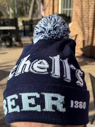 Navy blue stocking cap with Schell's logo on it.