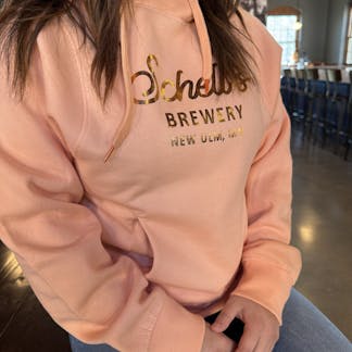Coral colored hood with gold lettering that says Schells.
