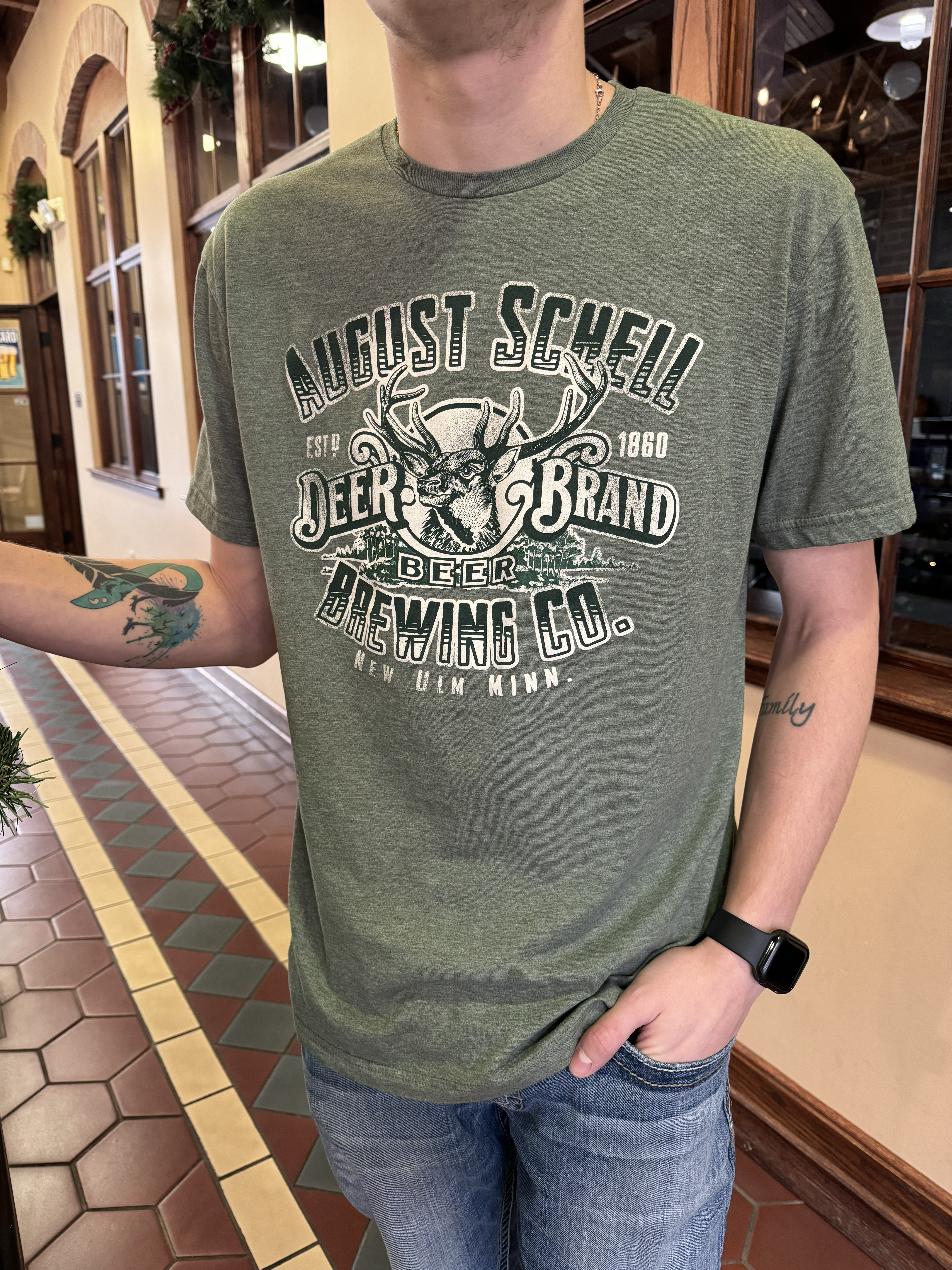 Green t-shirt with Schell logo on front.