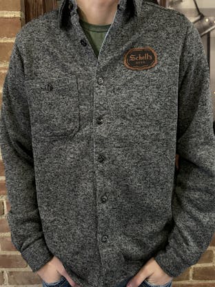 Grey button up shirt with Schell patch on left lapel.