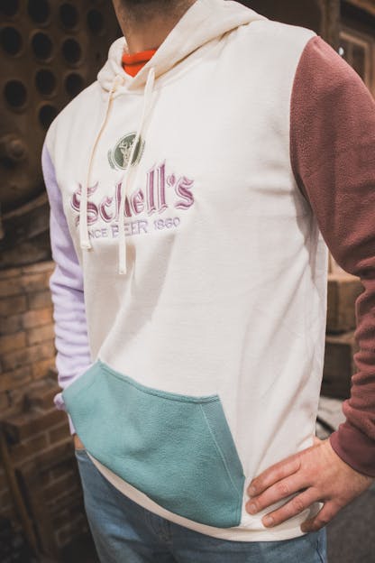 White sweatshirt with colored sleeves and Schell logo on front.