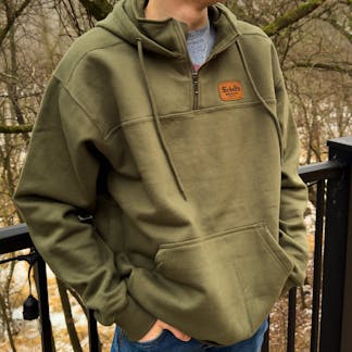 Olive colored quarter zip hood with Schell patch.