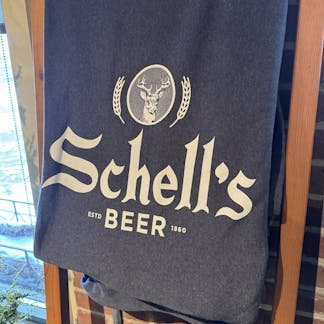 Fleece blanket with the Schell logo on it. Size is 76" by 62"