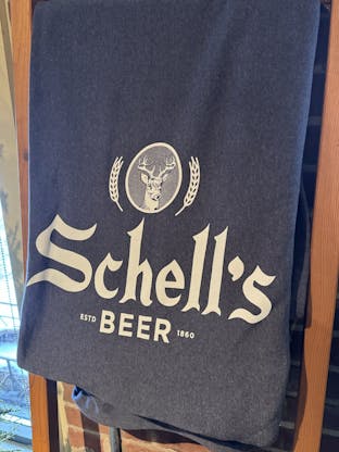 Fleece blanket with the Schell logo on it. Size is 76" by 62"