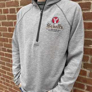 Light grey half zip sweatshirt with Schell logo on left lapel.