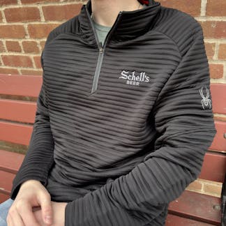 Black ribbed quarter zip sweatshirt with Schell logo on left lapel.