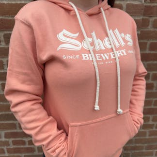 Apricot colored hooded sweatshirt with Schell logo on front.