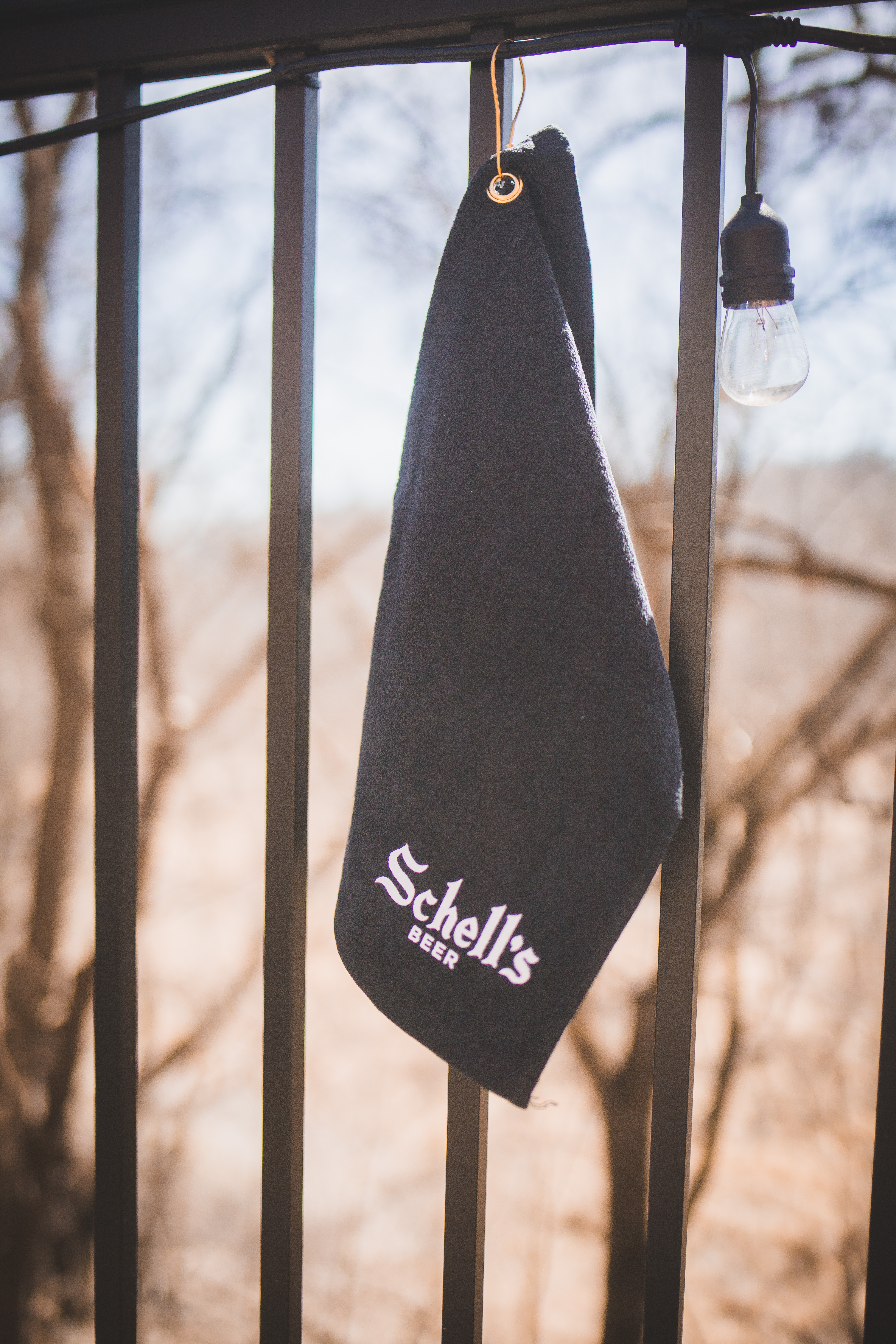 All black golf towel with clip and white Schell logo.