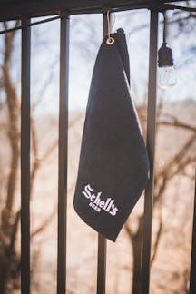 All black golf towel with clip and white Schell logo.