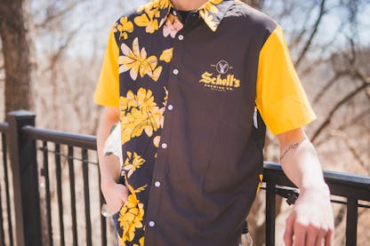 Gold and black Hawaiian style shirt with Schell logo on left lapel.
