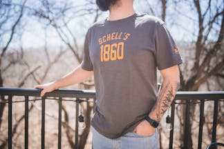 Grey t-shirt with Schell logo on front and left sleeve.