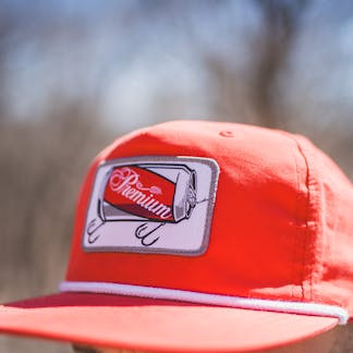 Red snapback hat with Grain Belt patch on front with a white rope.