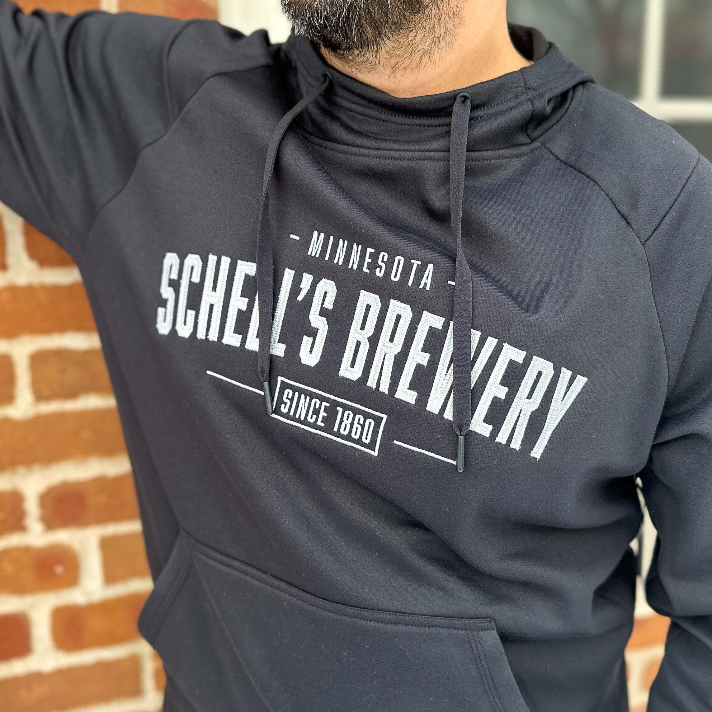 Black hooded sweatshirt with Schell logo on front.