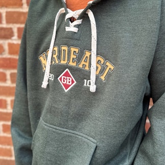 Green hooded sweatshirt with hockey lace strings and Nordeast logo on front.