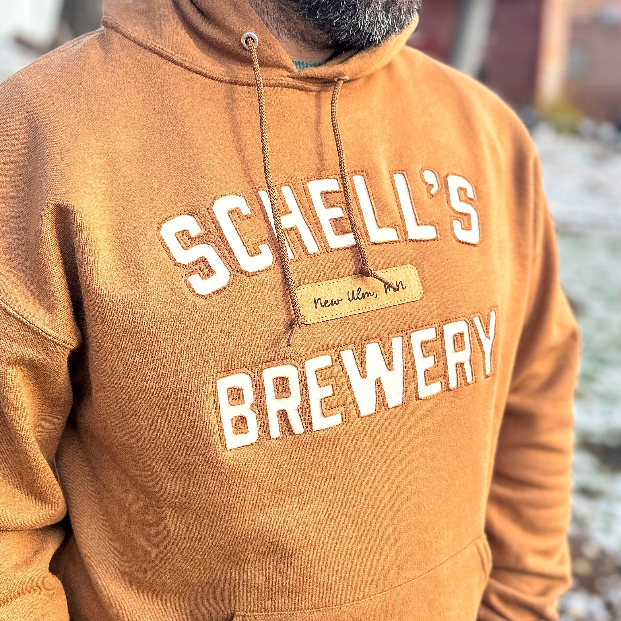 Brown colored hood with Schells logo on front.