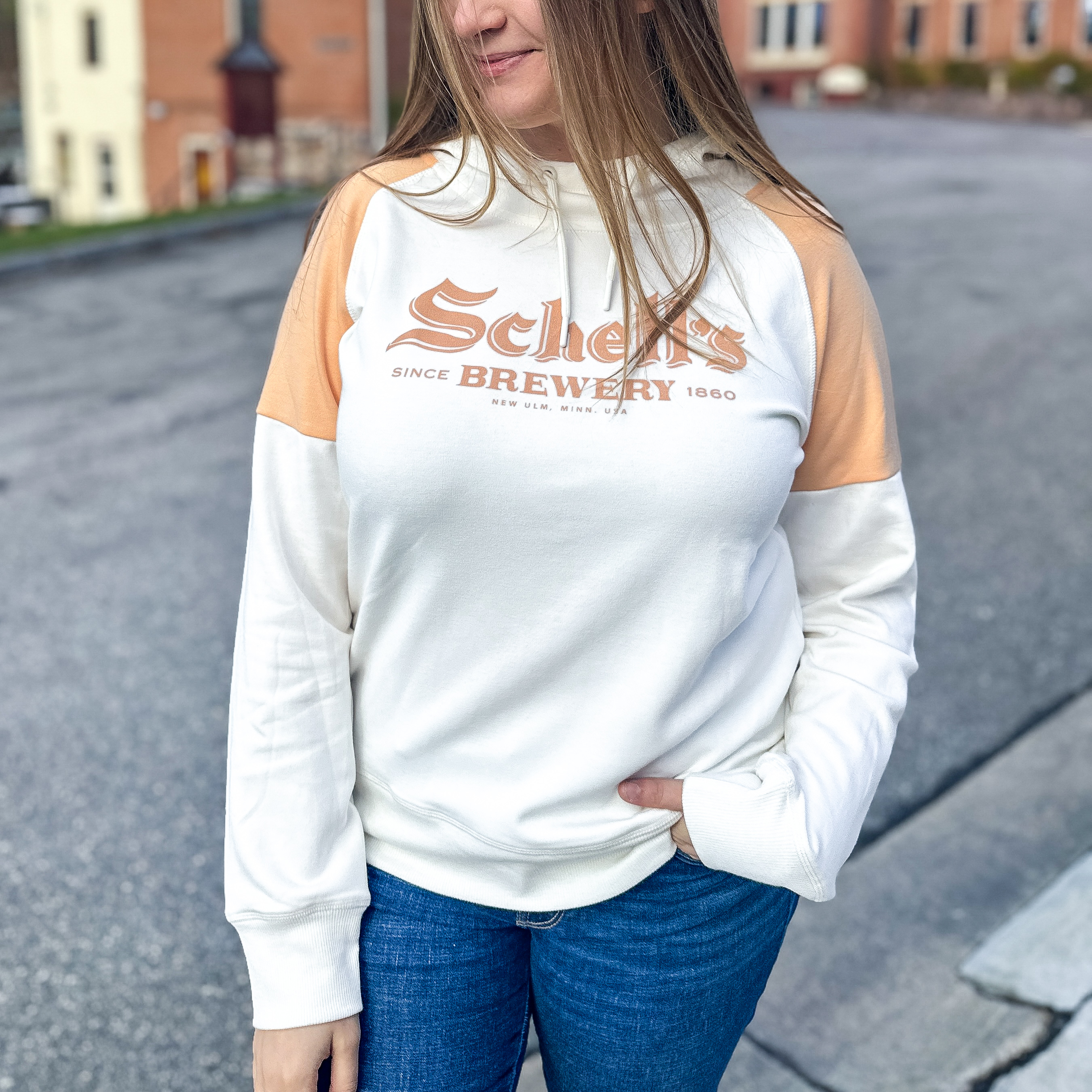 White and peach colored hood with Schells logo on front.