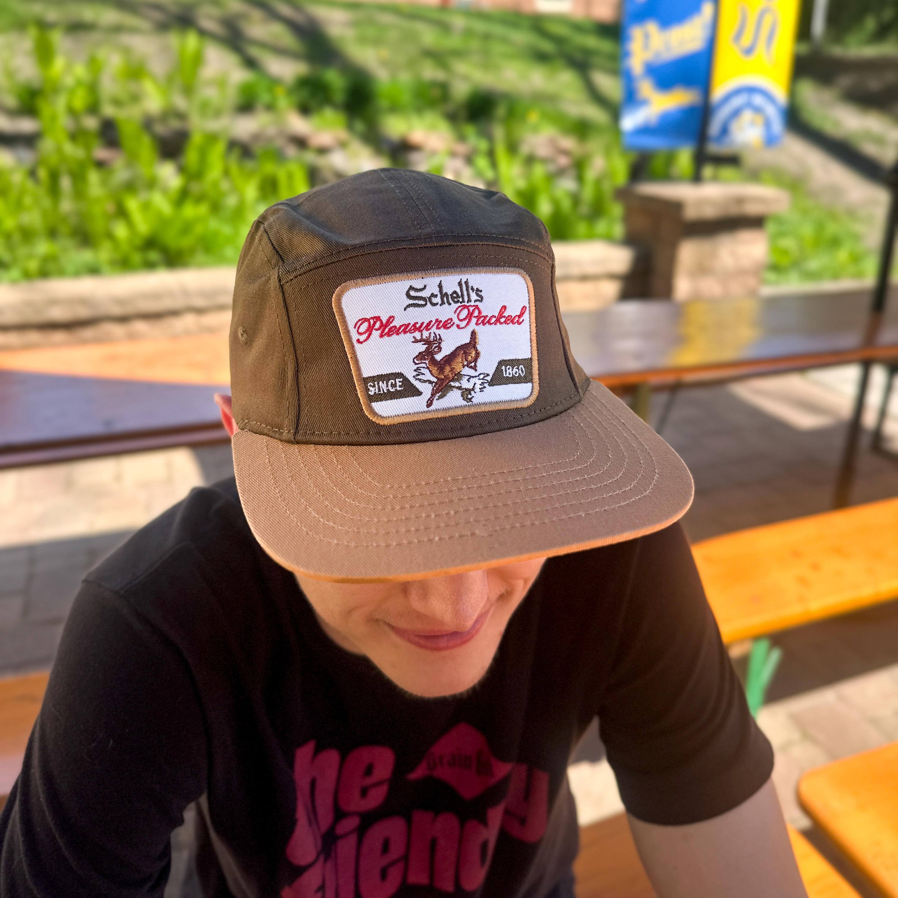 Brown and khaki baseball hat with Schell patch on the front.