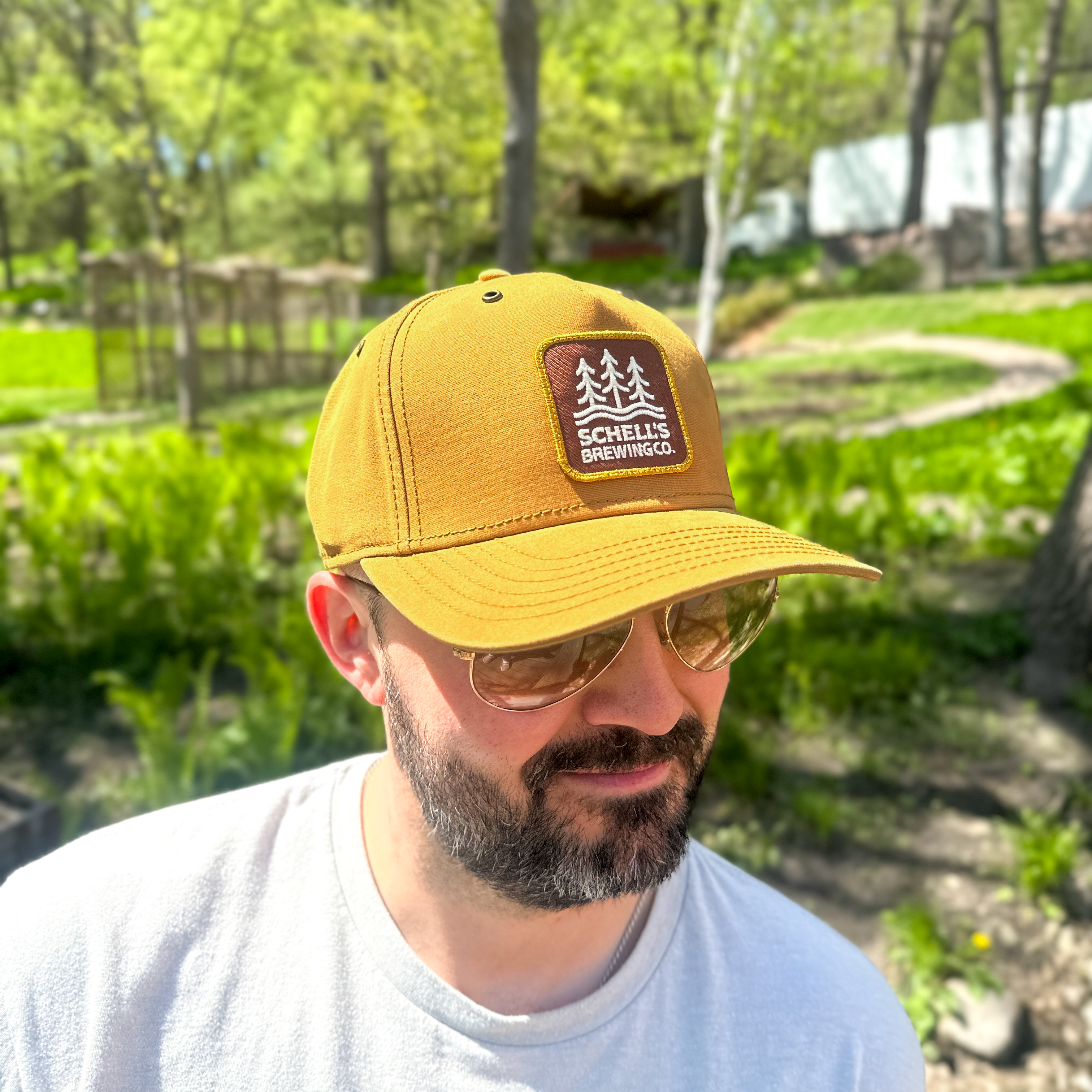 Tan baseball hat with Schell patch on the front.