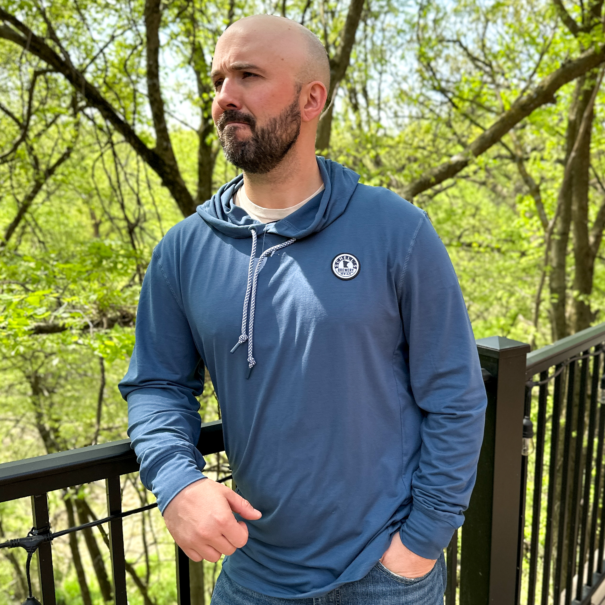 Navy blue lightweight hooded sweatshirt with Schell patch on the left lapel.