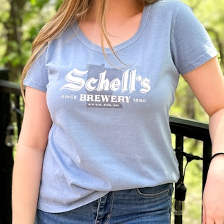 Dust blue colored tee with Schell logo on the front.