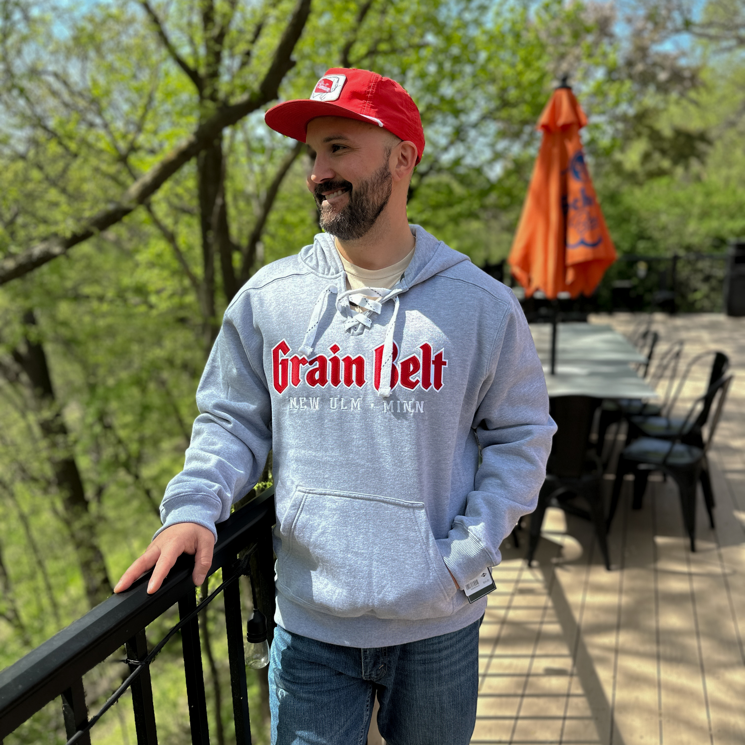 Grey hooded sweatshirt with white hockey ties and Grain Belt across the chest.