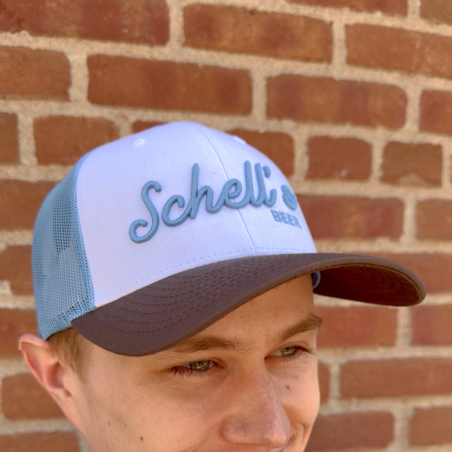 Brown, white and blue baseball hat with Schells on the front.