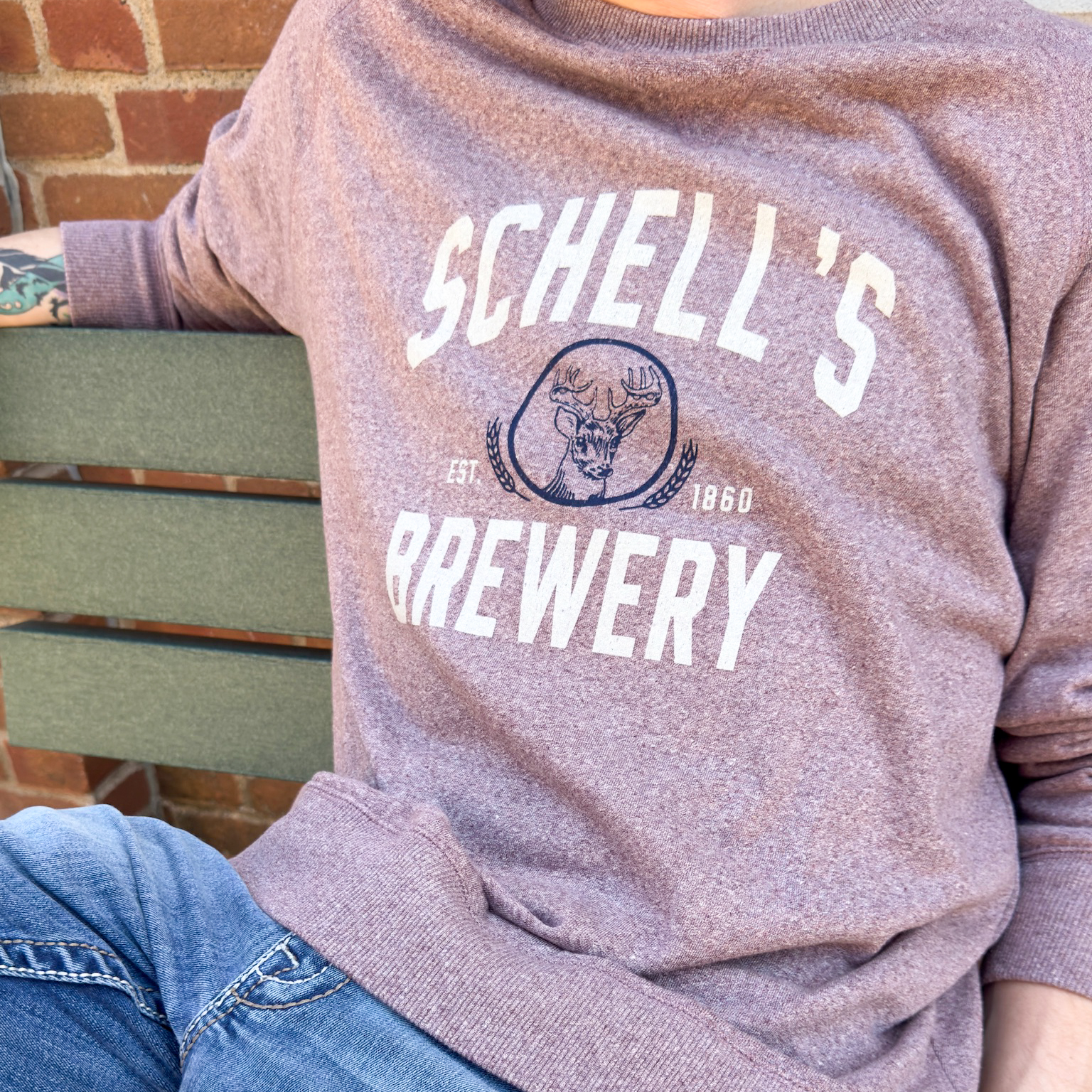 Red heather crew sweatshirt with Schell Logo on the front.