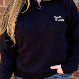 Black quarter zip sweatshirt with Schells on the left lapel.