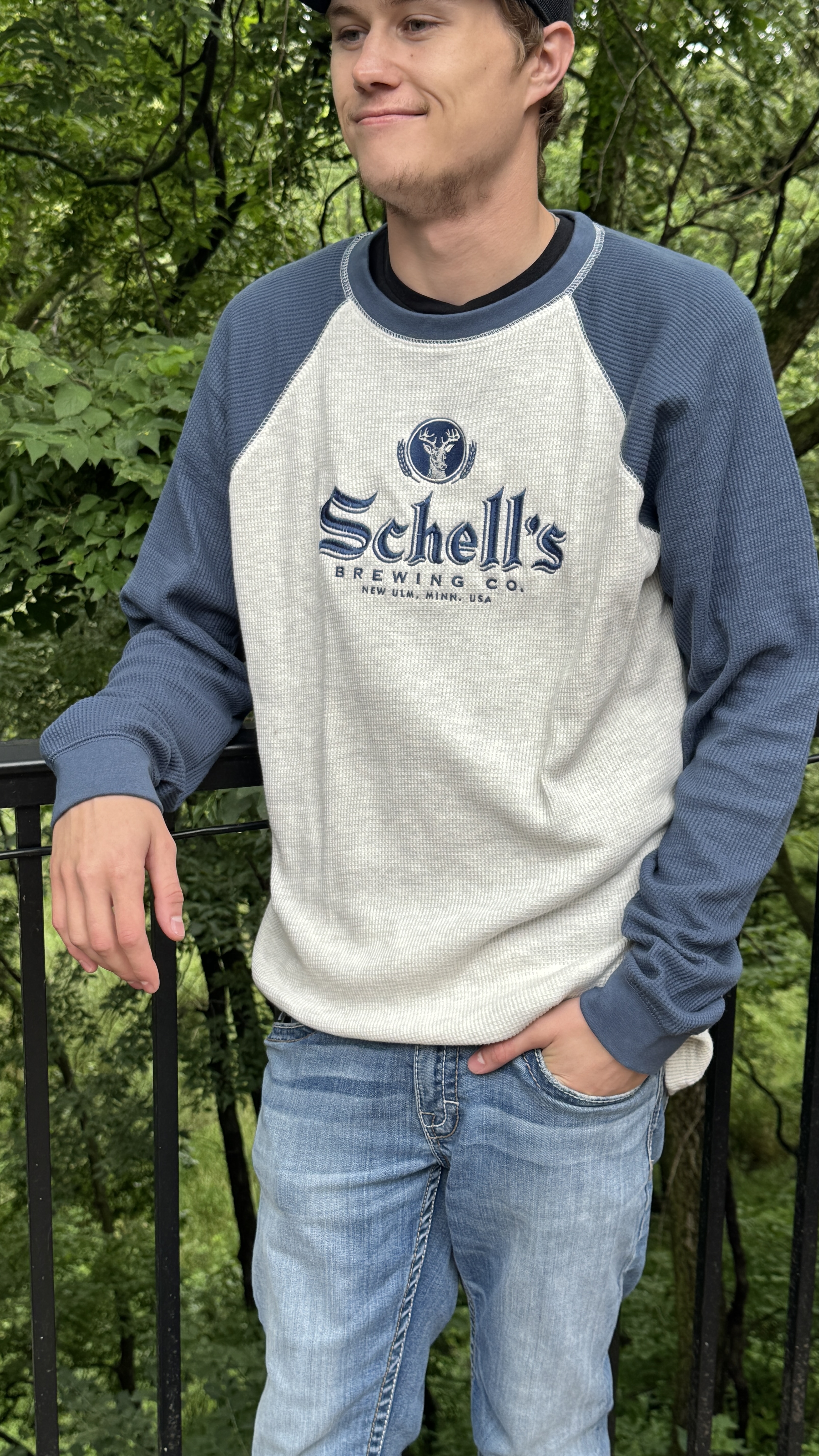White and navy blue long sleeve with Schell logo embroidered on the front chest.
