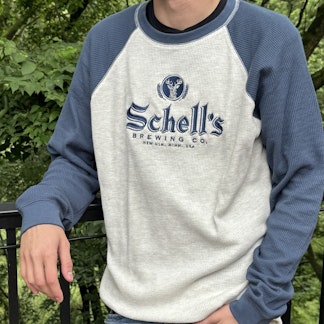 White and navy blue long sleeve with Schell logo embroidered on the front chest.