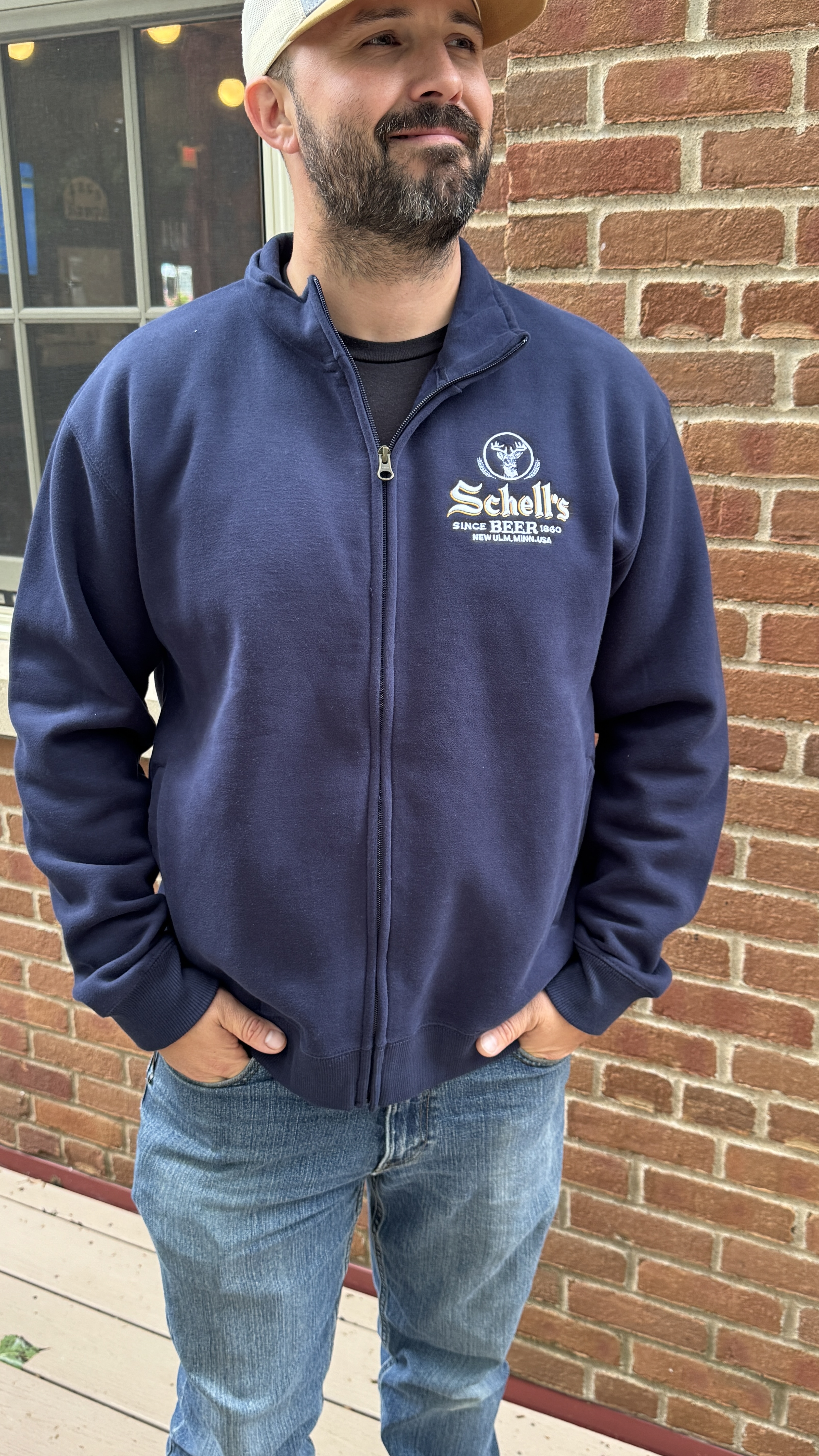 Navy blue full zip sweatshirt with Schell logo embroidered on left lapel.