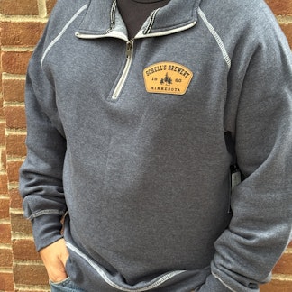Heather blue quarter zip sweatshirt with Schell logo embroidered on left lapel.