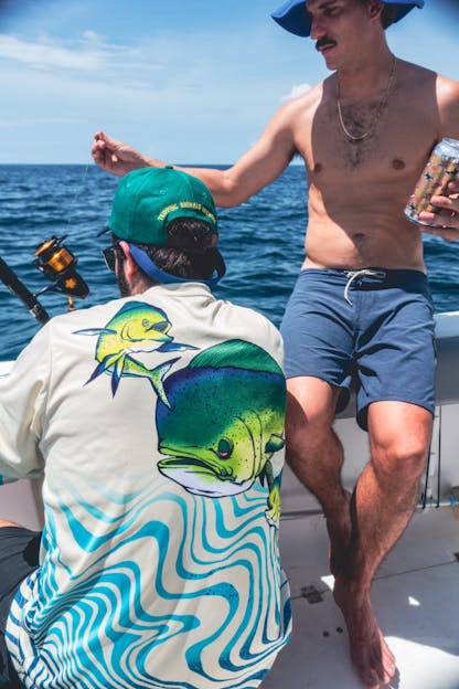 Two men out fishing, Enjoying beer from tripping animals brewing while wearing triple animals brewing merch