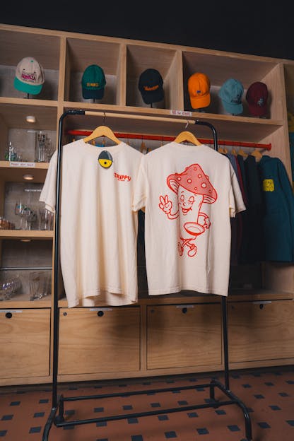 Image of trippy kitchen tshirts, showing a mushroom holding a pan in the back in red.