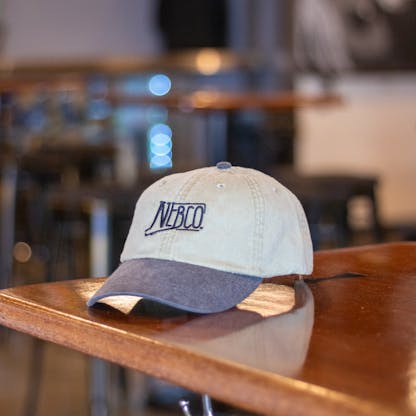 Tan NEBCO state logo hat with black brim and embroidery logo
