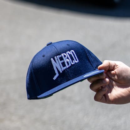 NEBCO logo navy hat being held