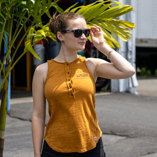 Female model wearing yellow New England Brewing embroidered yellow tank top and sunglasses