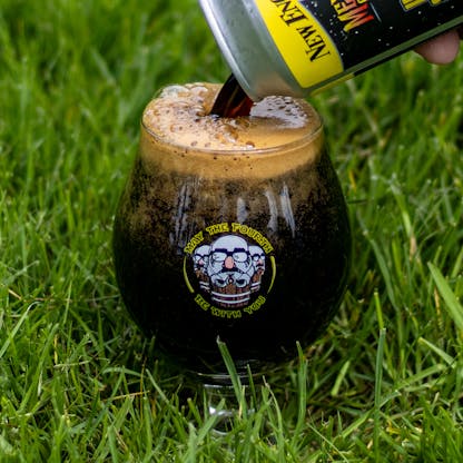 Snifter glass full of beer in grass