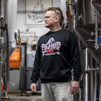 Male Model wearing 2 color Sea Hag beer logo on black crew neck sweatshirt