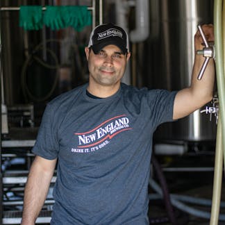 Male Model wearing short sleeve gray t-shirt with New England Brewing Company swoosh logo
