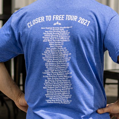 Close up of Closer to Free Tour sponsor list on back of blue T-shirt