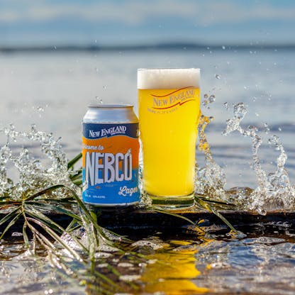 can of NEBCO Lager next to a full pint glass of beer