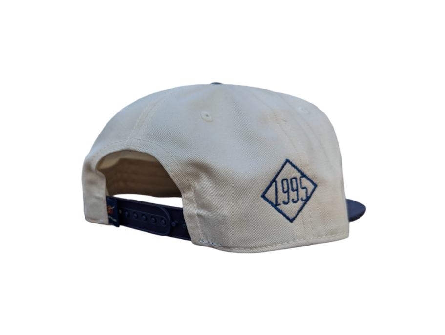 the side of a white ballcap with a blue diamond that reads 1995