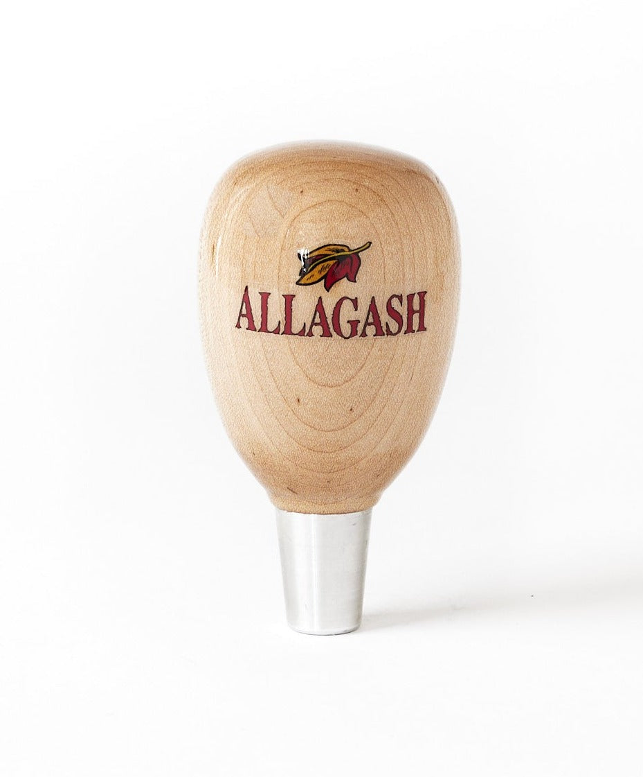 A rounded wooden taphandle with the text Allagash and a leaf logo