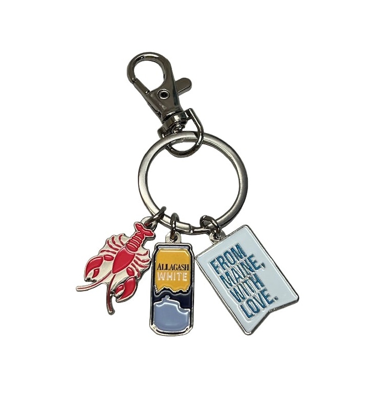 A keychain with 3 hanging trinkets. A lobster, a beer can and a flag that reads From Maine, With Love